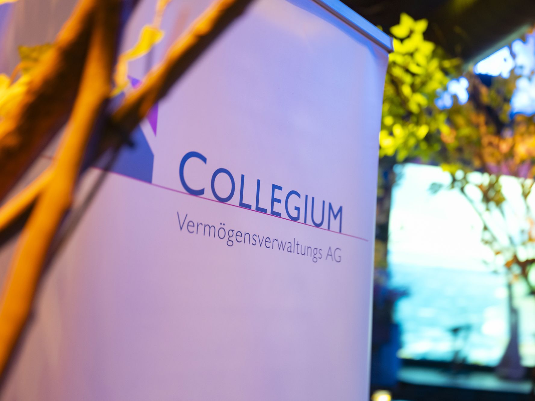 Roll Up mit COLLEGIUM Logo in stimmungsvollem Licht